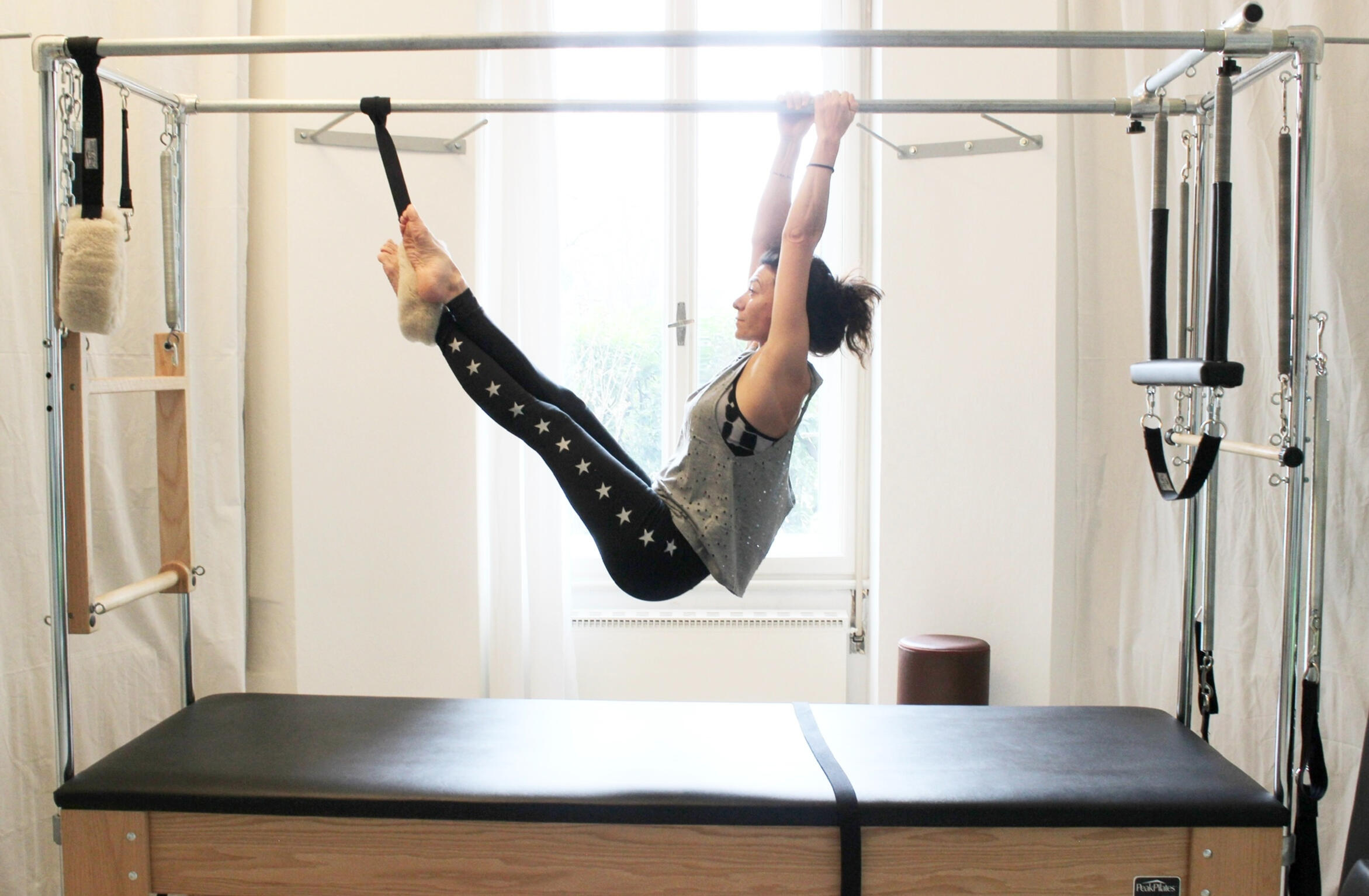 insegnante di pilates mentre svolge esercizio su macchina professionale Cadillac
